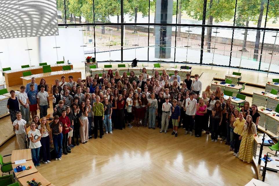 Großes Gruppenbild mit vielen Schülerinnen und Schülern im runden Plenarsaal des Sächsischen Landtages.